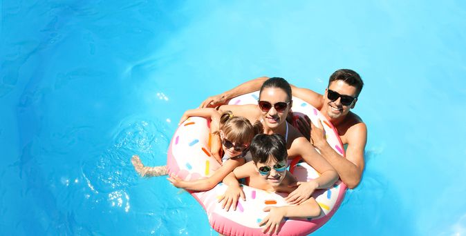 Eine Familie mit zwei Kindern und ein Schwimmreifen in einem Pool