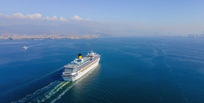 Weißes Kreuzfahrtschiff fährt bei Sonnigem Wetter über das Meer