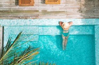 Eine Frau lehnt am Rand eines eleganten Pools