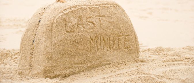 Ein aus Sand geformter Koffer mit der Aufschrift "Last Minute"