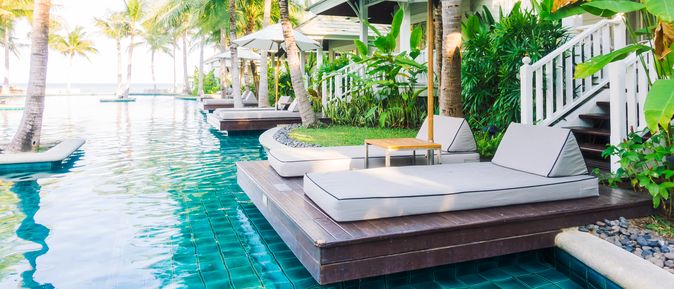 Zwei Liegen mit Sonnenschirm an einem Swim Up Pool