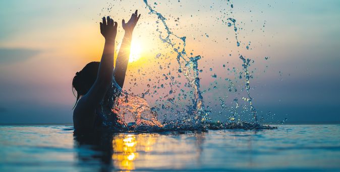 Frau im Pool bei Sonnenuntergang 