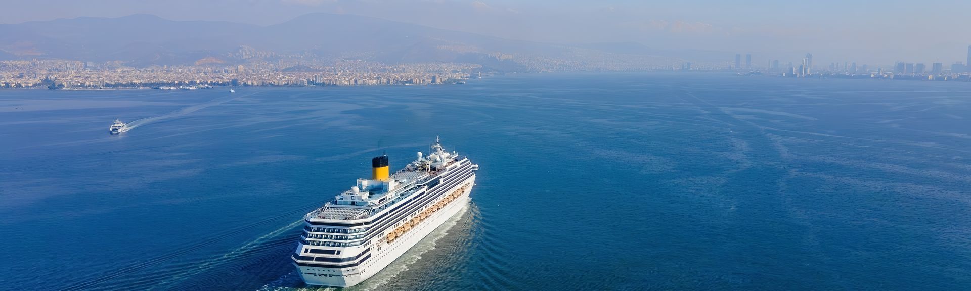 Weißes Kreuzfahrtschiff fährt bei Sonnigem Wetter über das Meer