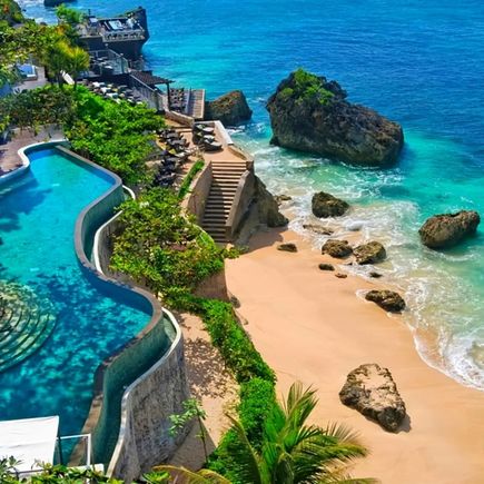 Infinity-Pool auf einer Terrasse oberhalb des Strandes. Unterhalb führt eine Treppe direkt zum Meer