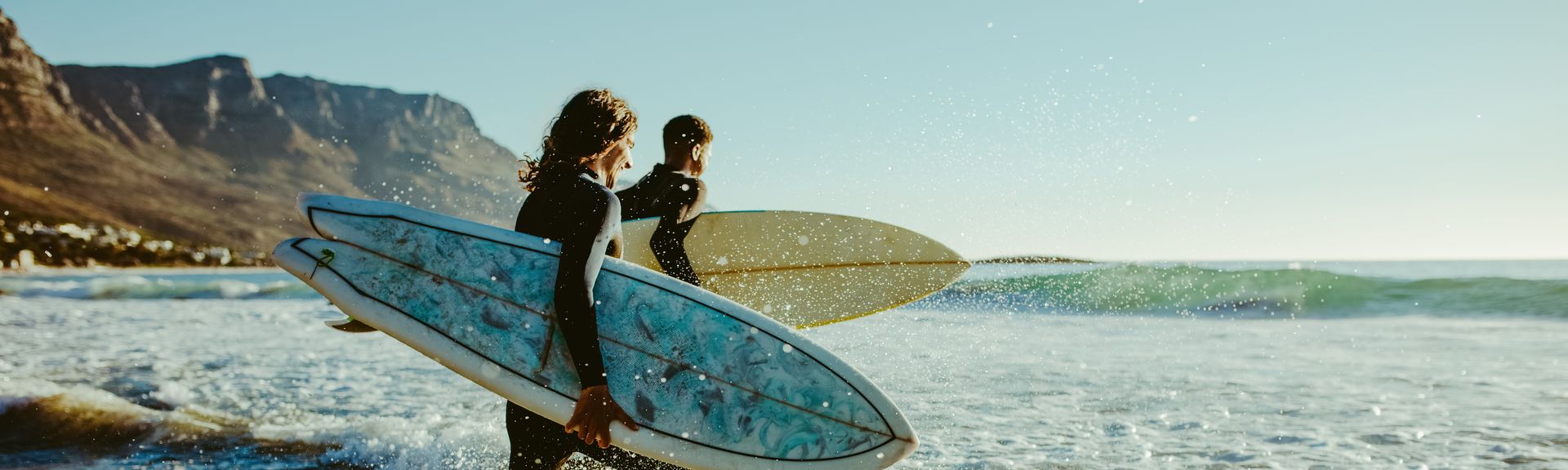 Surfer laufen auf das Meer zu