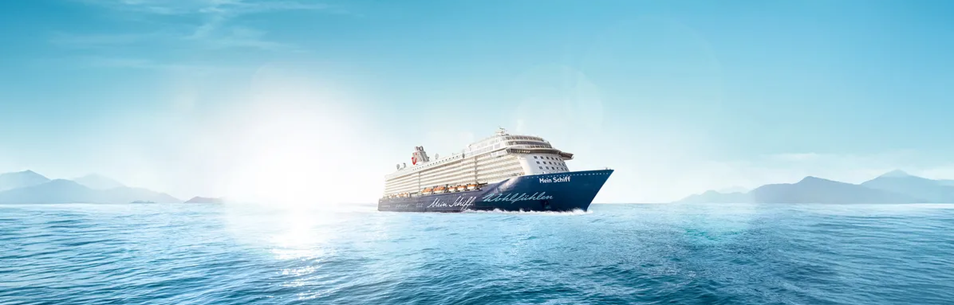 Ein Kreuzfahrtschiff fährt auf einem ruhigen Meer bei Sonnenschein
