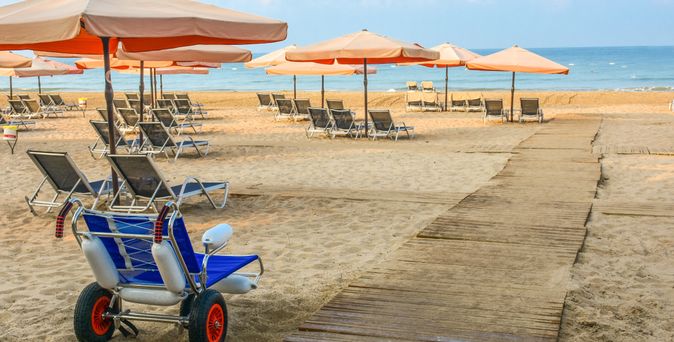 Strandrollstuhl auf einem barrierefreien Steg am Strand
