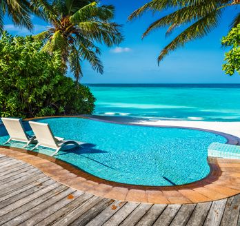 Ein kleiner Pool mit direktem Strandzugang und zwei Liegen