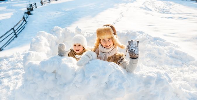 Zwei Kinder spielen im Schnee