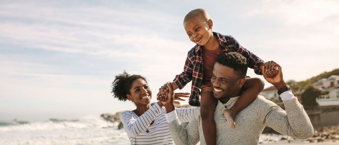 Eine Familie am Strand, Sohn sitzt auf den Schultern des Vaters