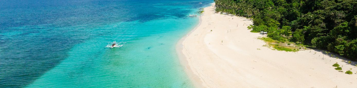 Sandstrand einer Insel mit einem Wald