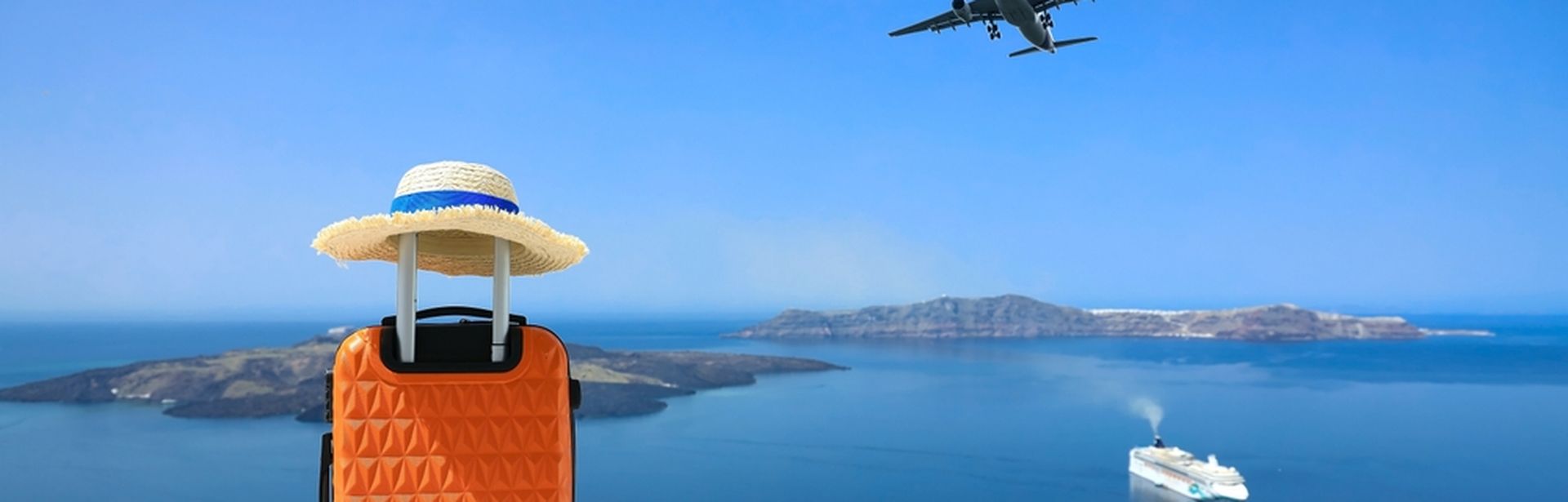 Ein Koffer steht auf einer Mauer, im Hintergrund sieht man das Meer und ein Schiff, im Himmel fliegt ein Flugzeug