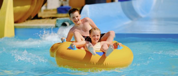 Zwei Kinder auf einem Schwimmring in einem Aquapark