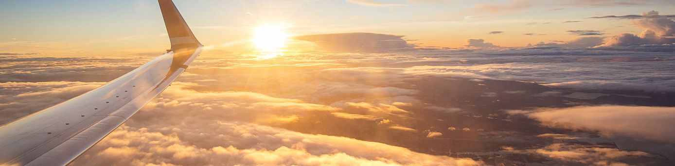 Sonnenuntergang über den Wolken aus einem Flugzeugfenster aus