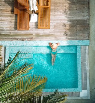 Eine Frau lehnt am Rand eines eleganten Pools