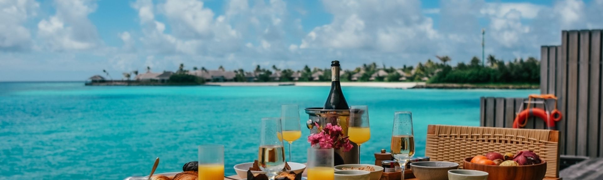Ein gedeckter Frühstückstisch auf einer Terrasse mit direktem Meerzugang