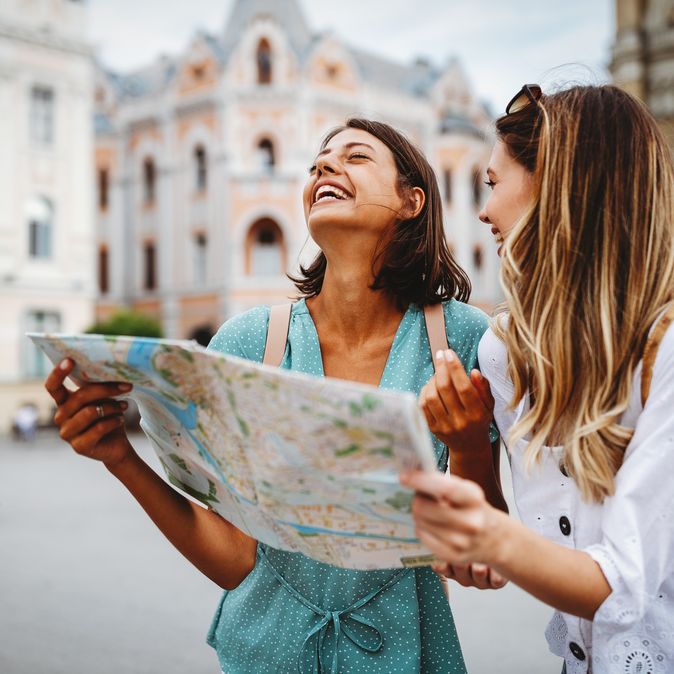 Zwei lachende Frauen mit einem Stadtplan