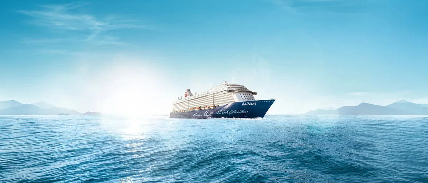 Ein Kreuzfahrtschiff fährt auf einem ruhigen Meer bei Sonnenschein