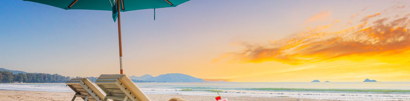 Zwei Liegen mit Sonnenschirm stehen am Strand
