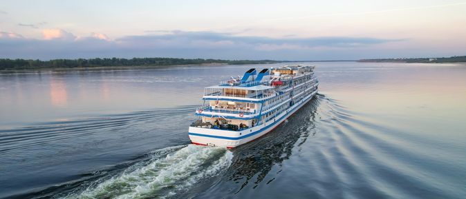 Flusskreuzfahrtschiff, dass auf einem breiten Fluss fährt