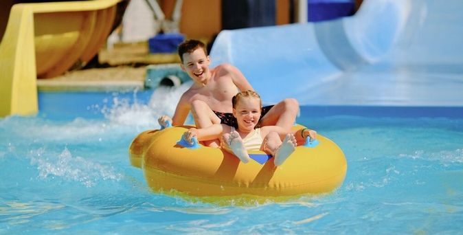 Zwei Kinder auf einem Schwimmring in einem Aquapark