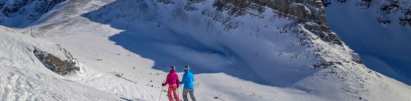 Zwei Menschen auf Skiern laufen durch eine verschneite Berglandschaft
