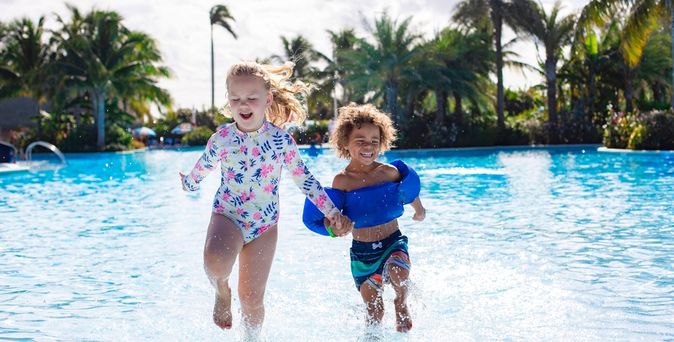 Zwei Mädchen laufen aus einem Pool raus