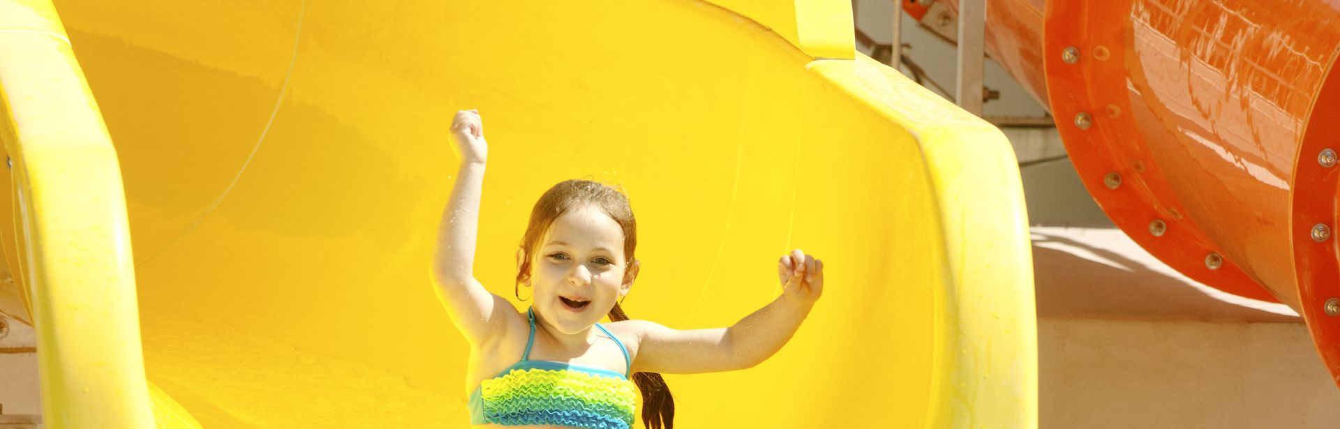 Mädchen rutscht glücklich auf einer Wasserrutsche