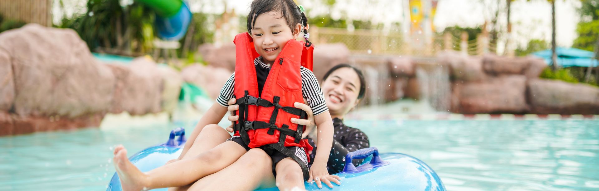 Mutter und Tochter auf einem Pool Floatie in einem Wasserpark