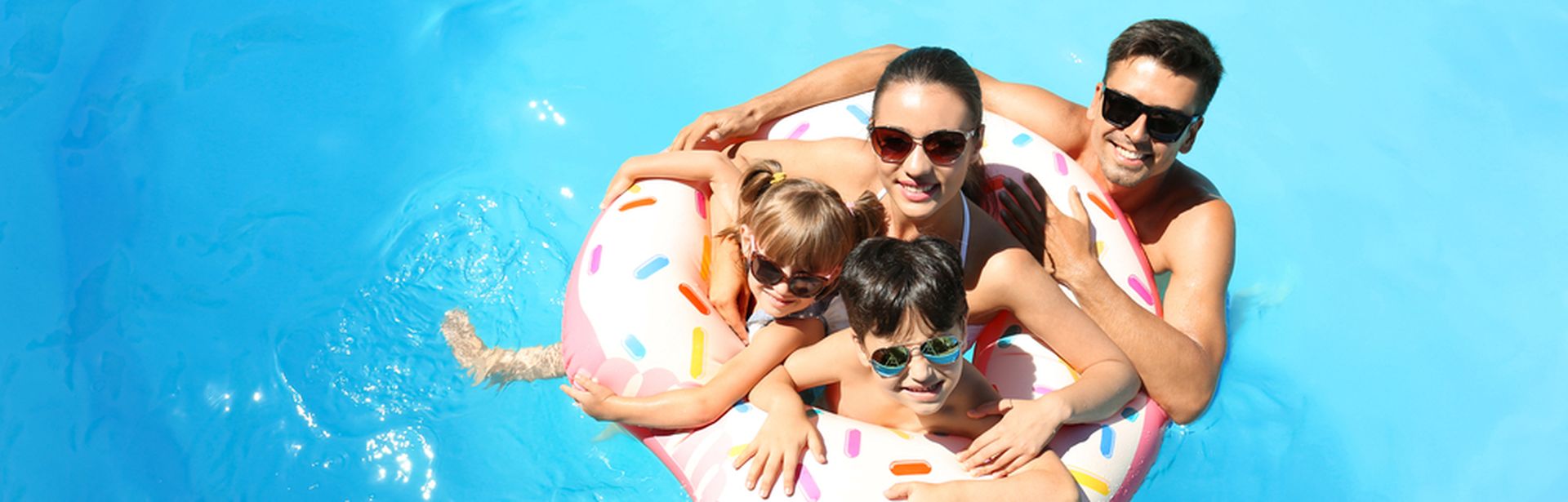 Eine Familie mit zwei Kindern und ein Schwimmreifen in einem Pool