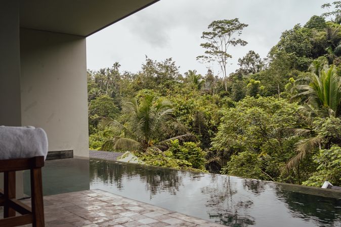 Blick auf einen Swim-up Pool mit Palmen im Hintergrund
