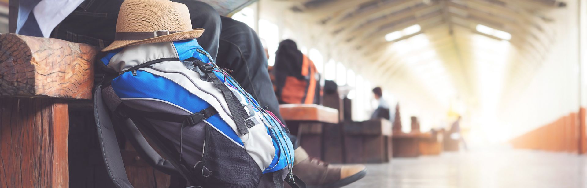Rucksack und Hut liegen am Bahnhof, Mann mit Stadtplan