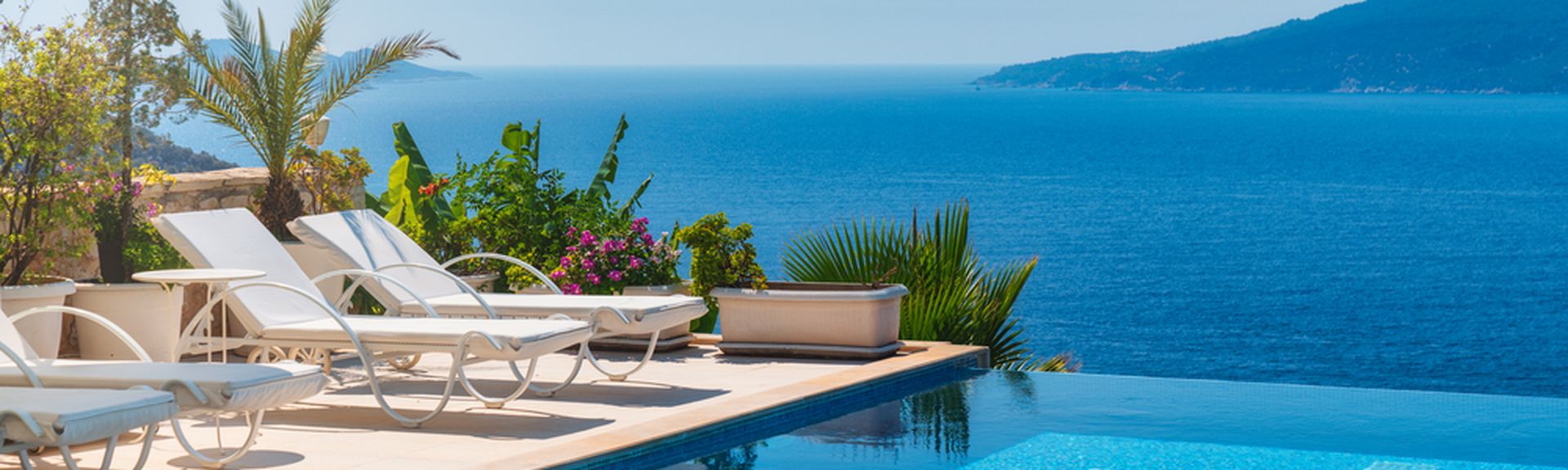 Infinity Pool mit Liegen und Blick auf das Meer