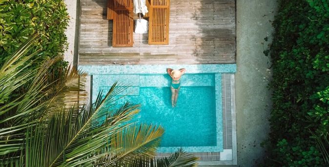 Eine Frau lehnt am Rand eines eleganten Pools