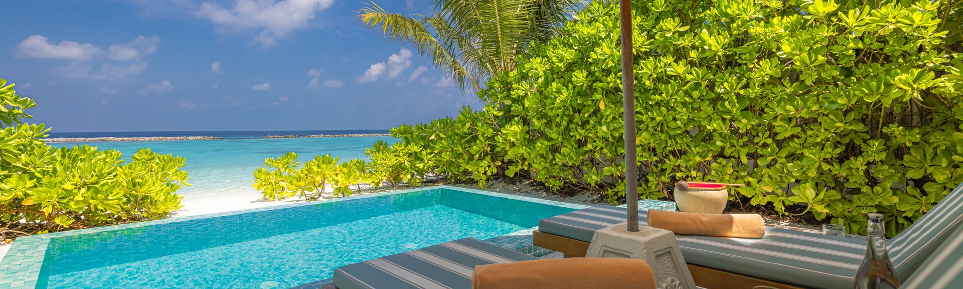 Private Pool mit zwei Liegen und einem Sonnenschirm