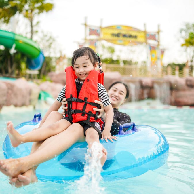 Mutter und Tochter auf einem Pool Floatie in einem Wasserpark