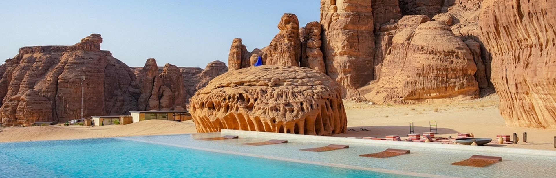 Pool umgeben von rot/braunen Steinfelsen