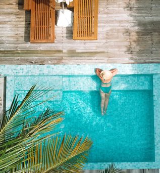 Eine Frau lehnt am Rand eines eleganten Pools