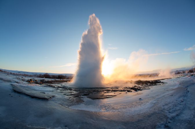 Ein Geysir bricht aus und schießt eine große Wassersäule in die Luft