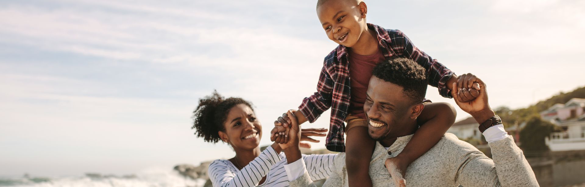 Eine Familie am Strand, Sohn sitzt auf den Schultern des Vaters