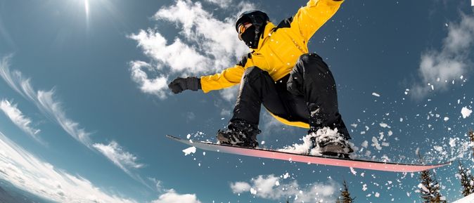 Mann auf einem Snowboard springt in der Luft