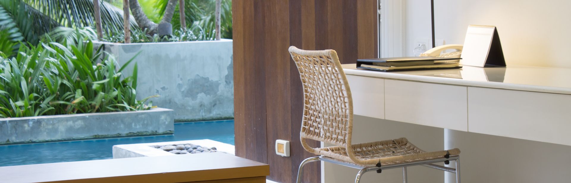 Ein Hotelzimmer mit Schreibtisch, im Hintergrund ein Swim-up Pool