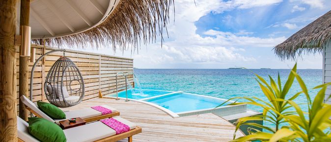 Eine Terrasse mit Privatpool und gemütlichen Liegen über dem Meer