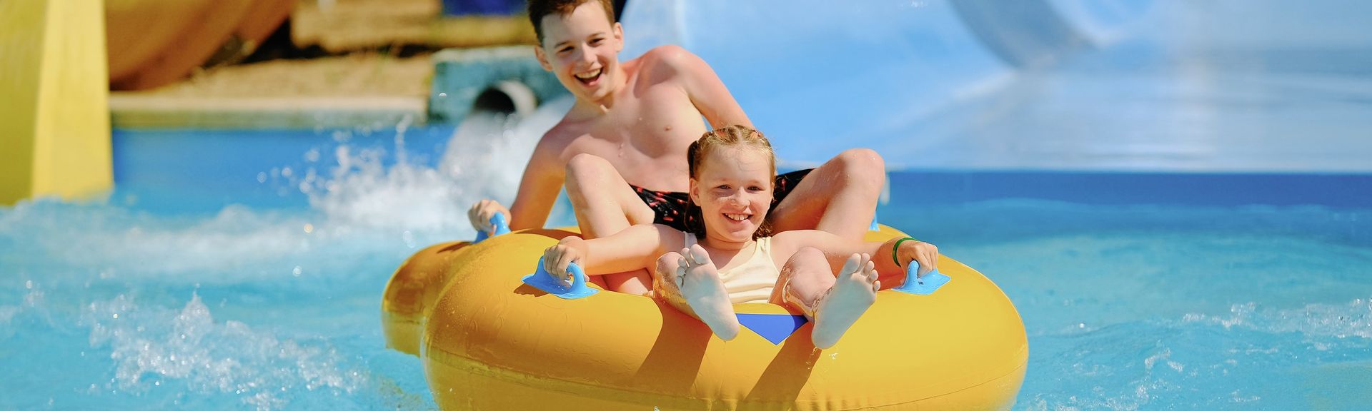 Zwei Kinder auf einem Schwimmring in einem Aquapark