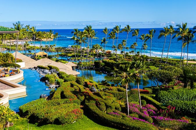 Ein Hotel mit mehreren Pool, Palmen und Strandzugang