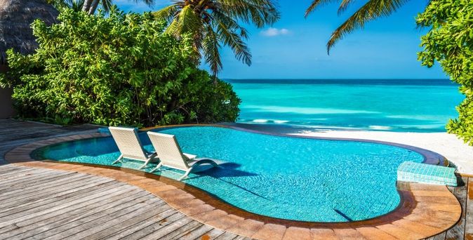 Ein kleiner Pool mit direktem Strandzugang und zwei Liegen