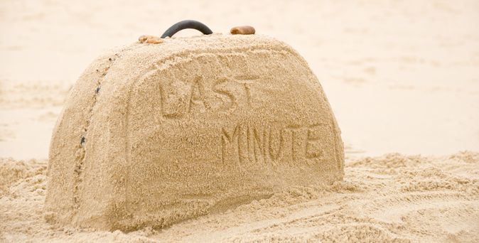 Ein aus Sand geformter Koffer mit der Aufschrift "Last Minute"