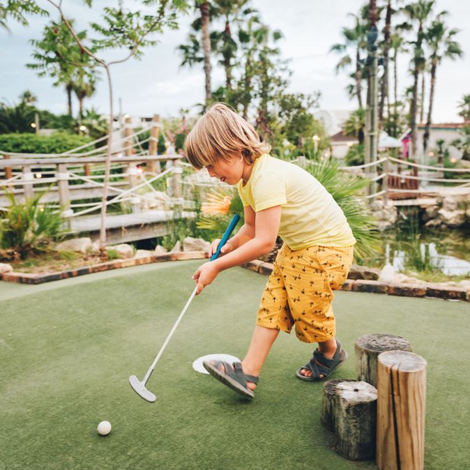 Ein junge spielt Minigolf