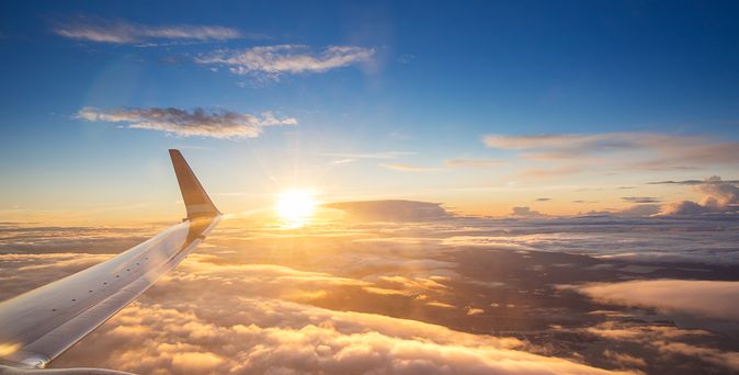Sonnenuntergang über den Wolken aus einem Flugzeugfenster aus