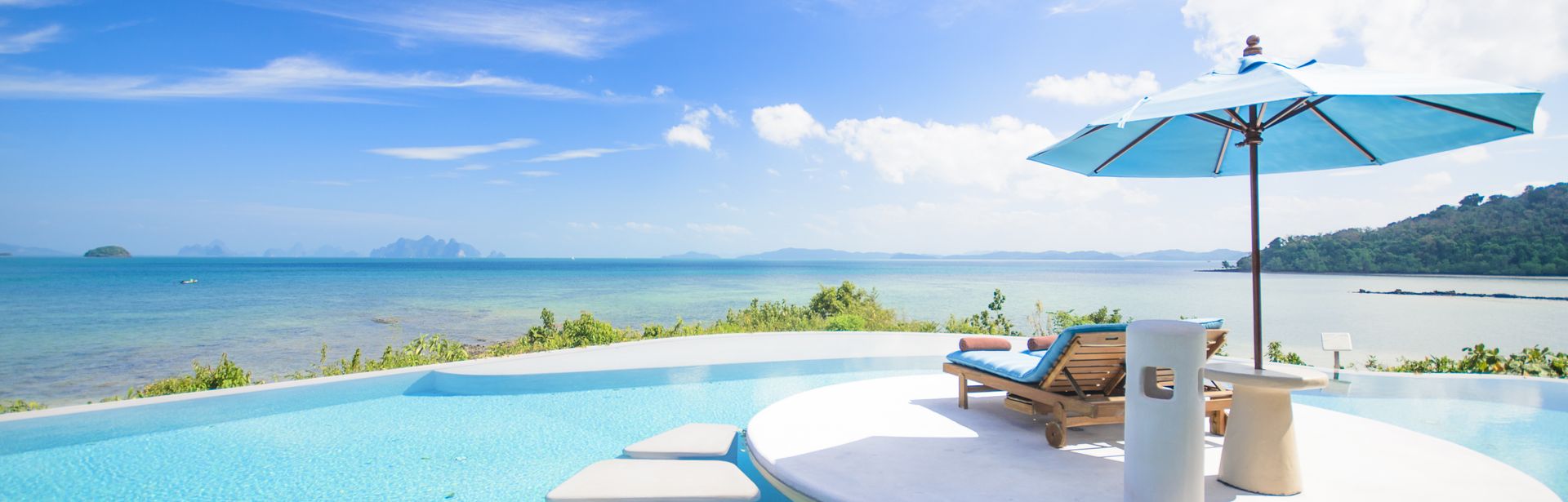 Ein Tisch mit kleinem Sonnenschirm und Getränken steht im Pool